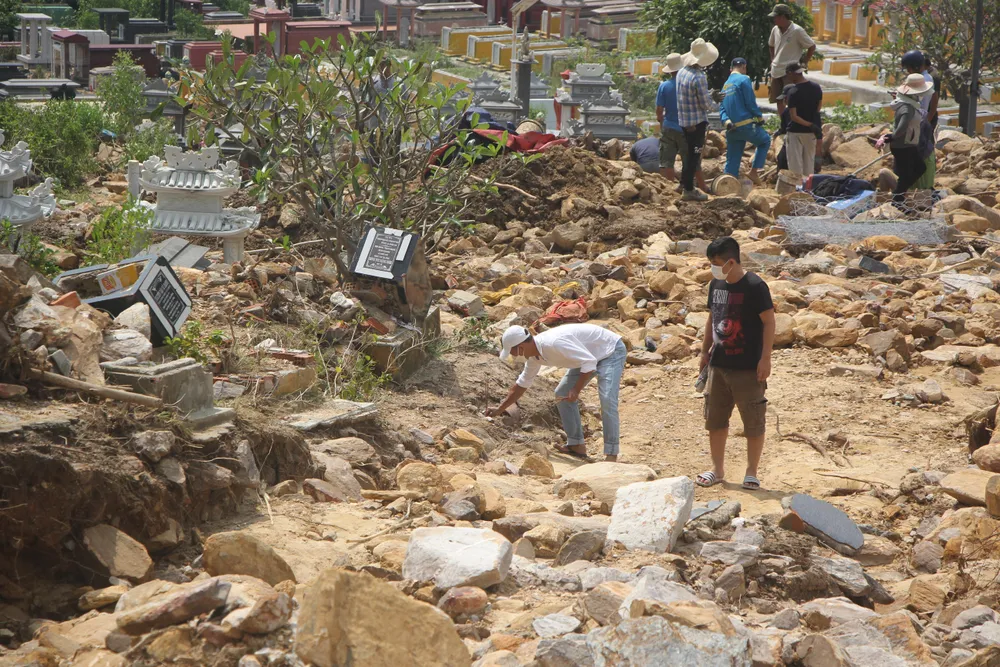Người dân đi tìm các phần mộ bị chôn vùi trong đất đá-Ảnh: NGÔ QUANG Người dân đi tìm các phần mộ bị chôn vùi trong đất đá-Ảnh: NGÔ QUANG