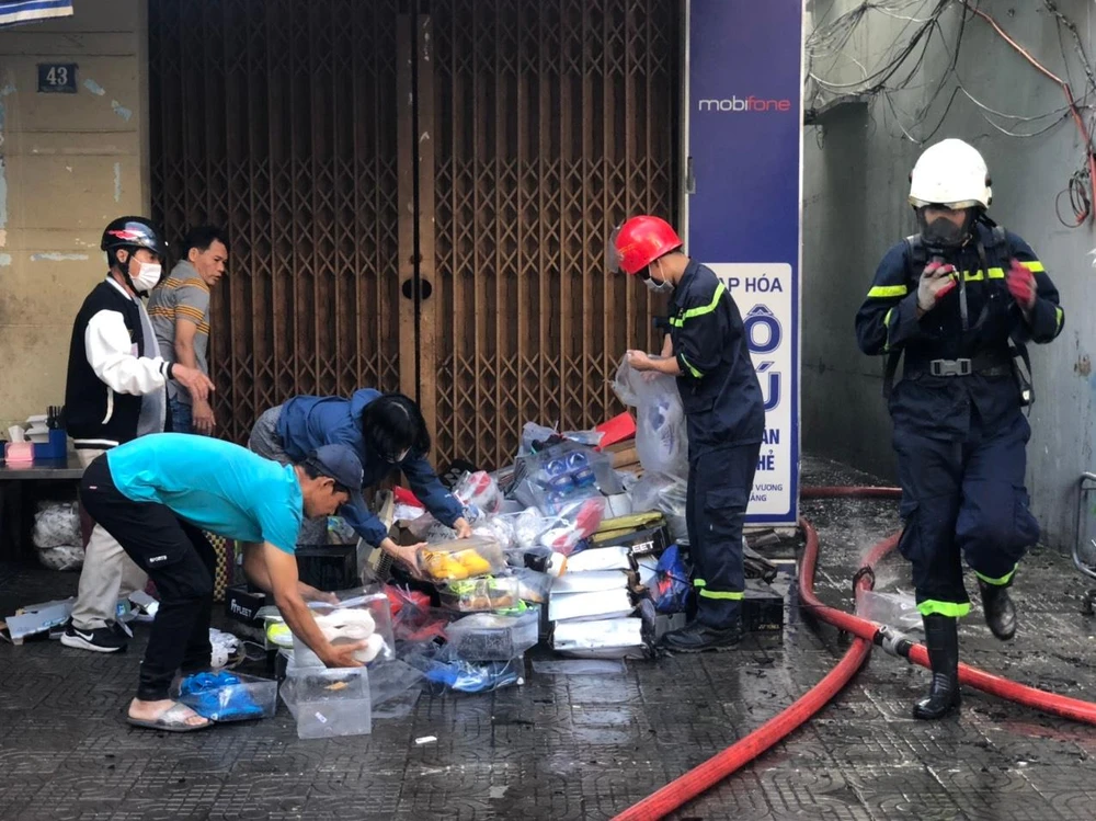 Lực lượng PCCC hỗ trợ cứu tài sản giùm chủ hộ. Ảnh: NGÔ QUANG