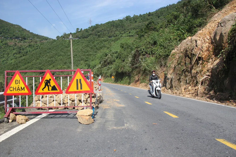Hiện tuyến đường đã thông, lực lượng chức năng xếp rọ đá để gia cố một số điểm nguy hiểm, đặt biển cảnh báo ATGT các điểm sạt lở, các điểm đá lăn. Ảnh: NGÔ QUANG