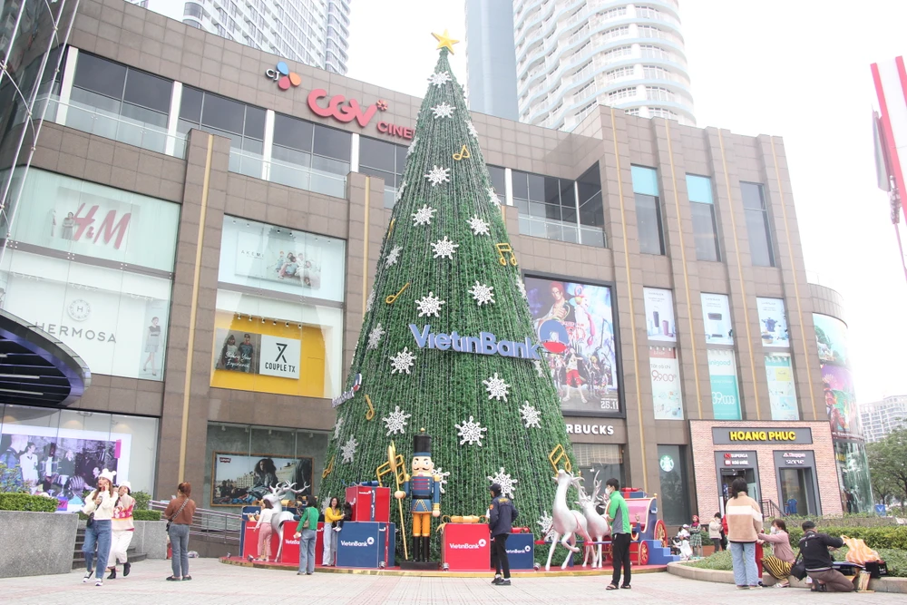 Tại một trung tâm thương mại, cây thông Noel lớn được đặt trước cổng để người dân tham quan, vui chơi, chụp ảnh.