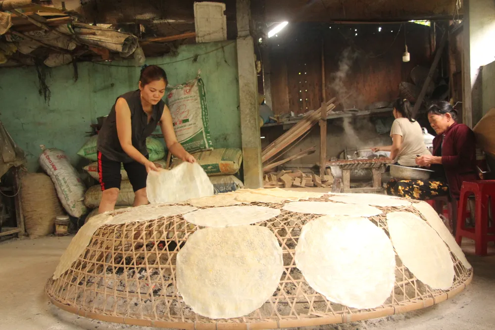 Chị Đặng Thị Anh Thư đang phụ giúp trải bánh lên phơi. Ảnh: NGÔ QUANG. Chị Đặng Thị Anh Thư đang phụ giúp trải bánh lên phơi. Ảnh: NGÔ QUANG.