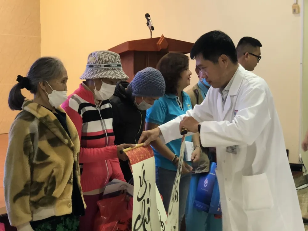 Ông Nguyễn Thành Trung, Phó giám đốc Bệnh viện Đà Nẵng trao phần quà câu đối thư pháp cho các bệnh nhân. Ảnh: NGÔ QUANG.