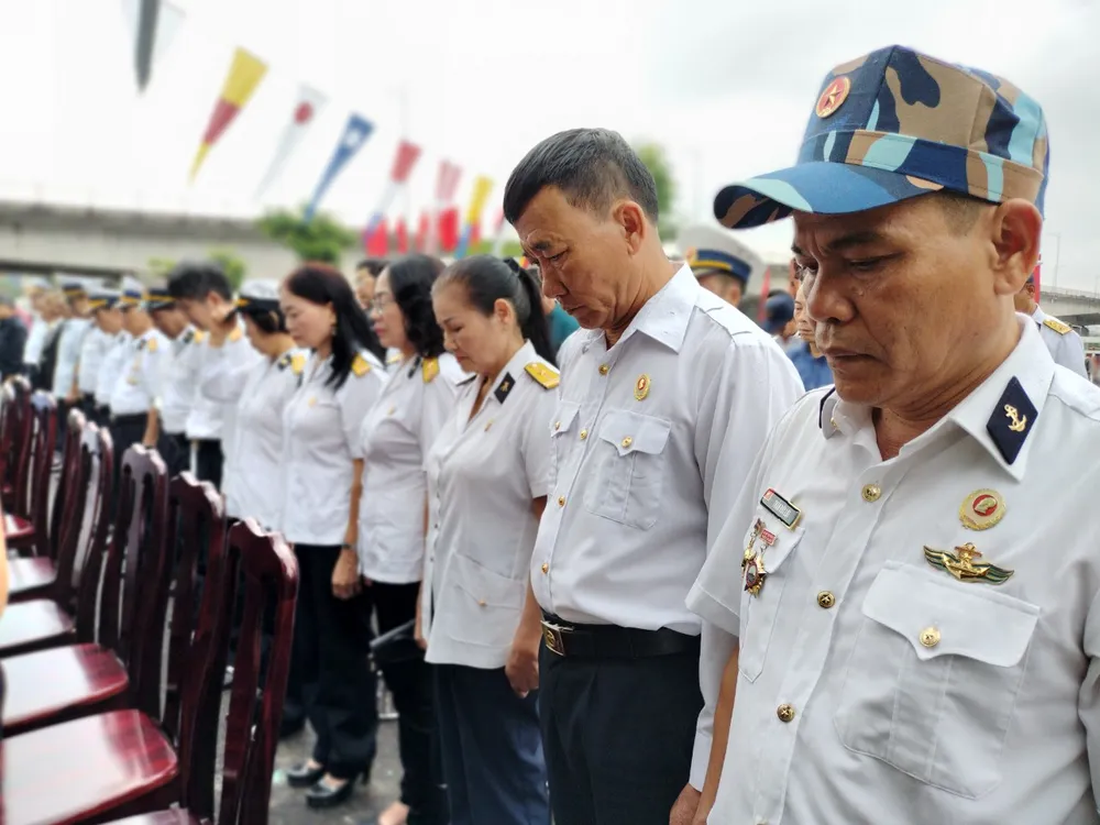Đồng đội cúi đầu tưởng niệm 64 liệt sĩ đã anh dũng hi sinh ở đảo Gạc Ma.Ảnh: NT