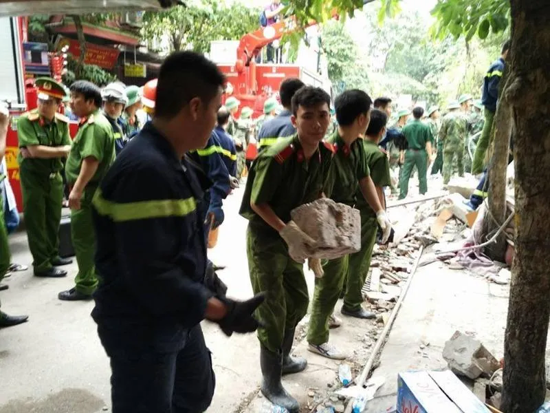 Lực lượng cứu hộ phải chuyển từng viên gạch ra để cứu hộ 2 người còn lại trong ngôi nhà.