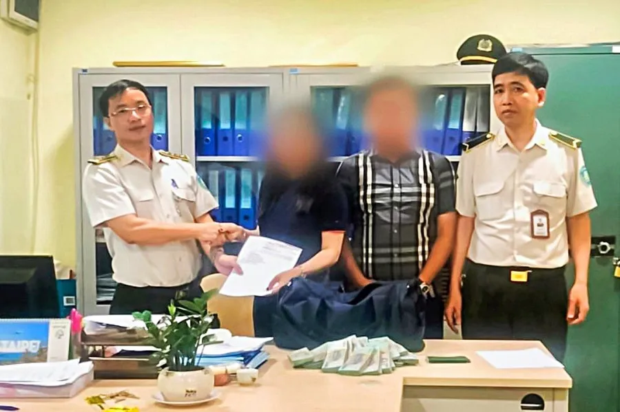 Hành khách nhận lại túi tiền bỏ quên ở sân bay. Ảnh: N.HÀ