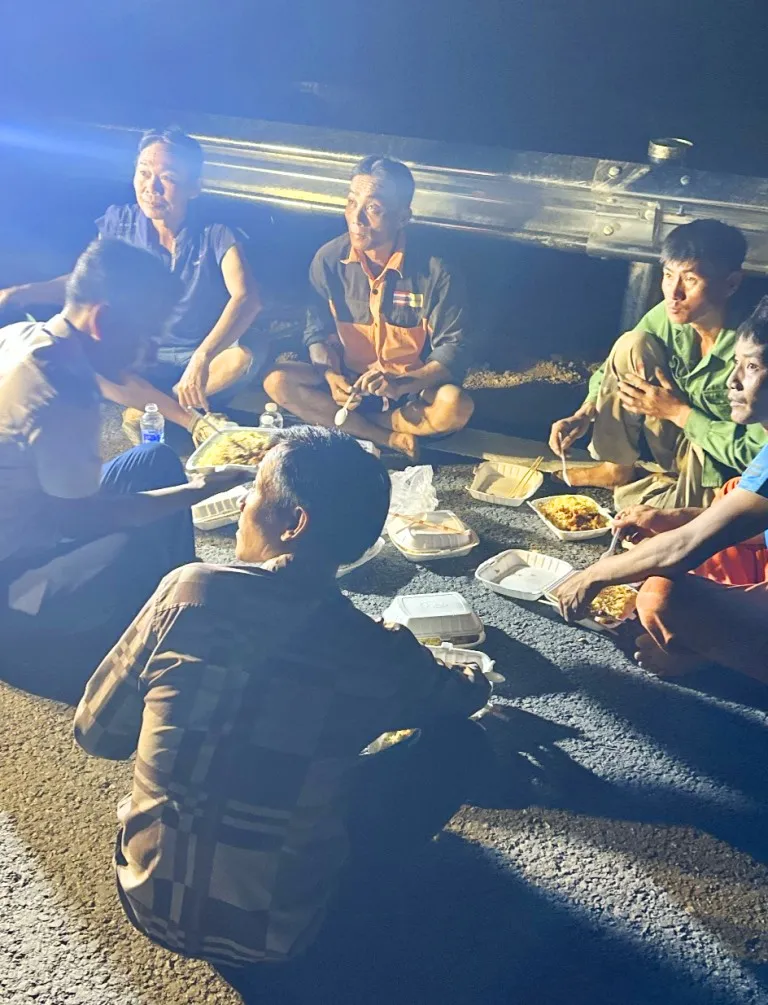 Công nhân ăn tối trên công trường để làm tiếp ca đêm cho kịp ngày thông xe. Ảnh: CTV