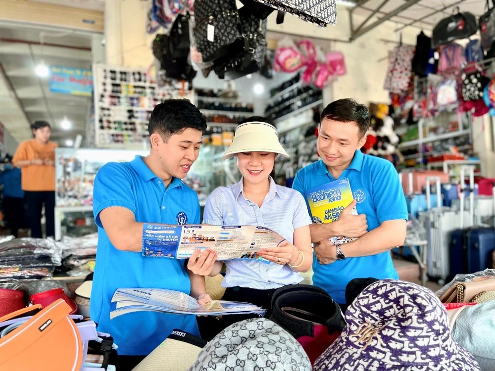 Nhân viên BHXH Việt Nam hướng dẫn người dân tham gia BHXH tự nguyện.