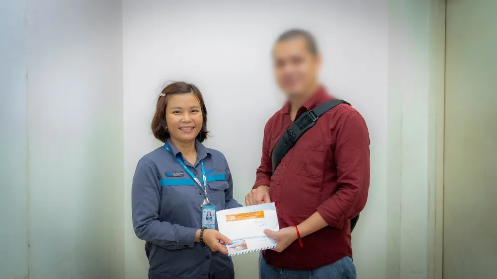 Chị Hà Thị Tươi, nhân viên Đội xe đẩy, Trung tâm Khai thác ga sân bay Nội Bài trả lại tiền cho khách. Ảnh: N.LONG