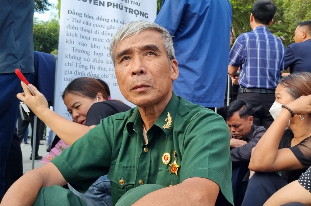 Thức trắng đêm chờ tiễn biệt Tổng Bí thư Nguyễn Phú Trọng về với Đất Mẹ ảnh 1 Ông Nguyễn Văn Quế ngồi chờ đến lượt vào tiễn biệt Tổng Bí thư Nguyễn Phú Trọng. Ảnh: V.LONG