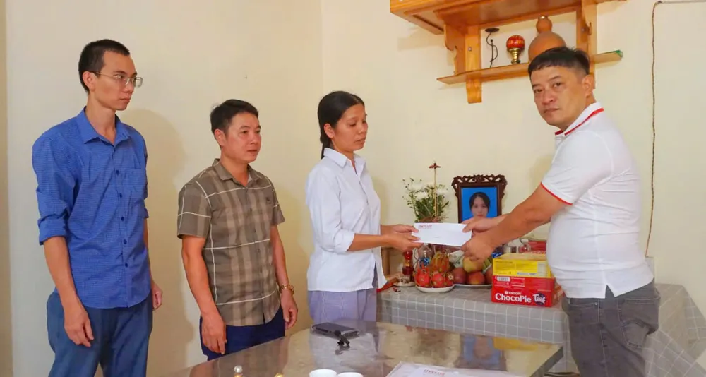 Anh Hoàng Nghĩa Nhân (áo trắng bên phải) trao quà hỗ trợ của bạn đọc đến gia đình chị Đinh Thị Niên. Ảnh: N.HINH sap-cau-phong-chau.jpg