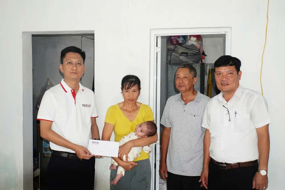 Đại diện Báo Pháp Luật TP.HCM trao quà của bạn đọc cho chị Đỗ Thị Năm trước sự chứng kiến của lãnh đạo chính quyền thị trấn Cát Bà. Ảnh: NGỌC SƠN bao-phap-luat-tphcm-2.jpg