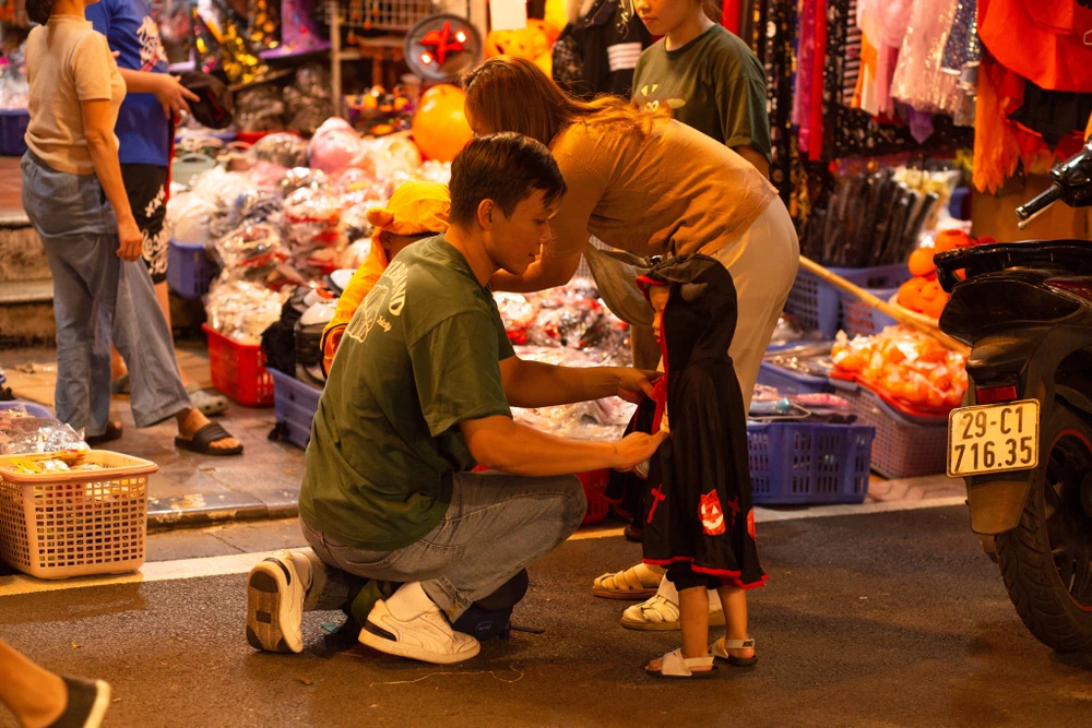 Bạn nhỏ được bố mẹ mua sắm đồ dịp lễ Halloween. Ảnh: T.HẰNG