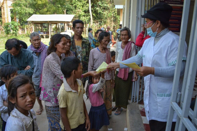 Nhân viên y tế phát phiếu xét nghiệm HIV cho dân làng Roka hồi cuối tháng 12-2014 - Ảnh:The Cambodia Daily