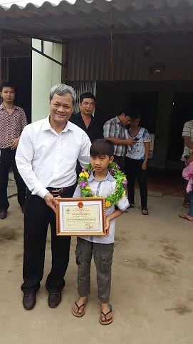Ông Nguyễn Tử Quỳnh phó chủ tịch thường trực UBND Tỉnh trao bằng chứng nhận cho em Vĩnh