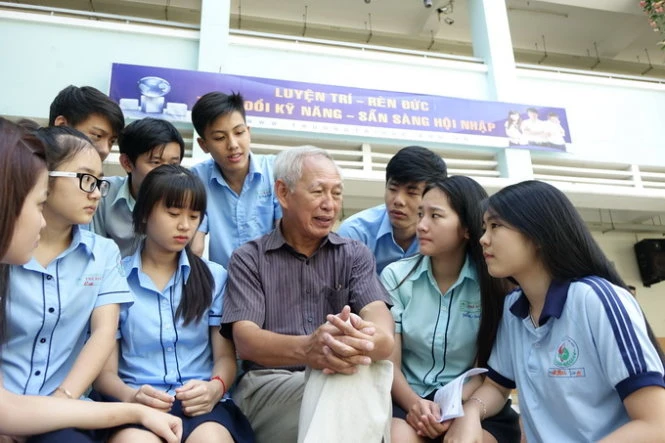 Thầy Hồ Hoàng Minh trò chuyện với học sinh trong giờ ra chơi - Ảnh: N.Hùng