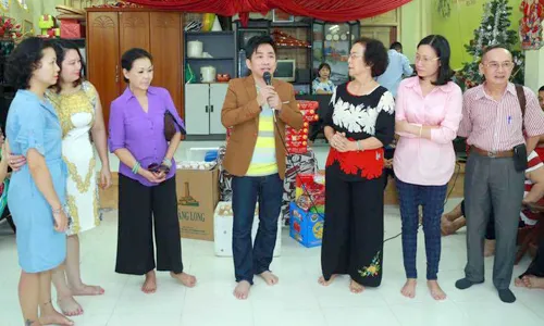 Khánh Ly và ca sĩ Quang Thành (thứ ba, thứ tư từ trái qua) đến thăm một trung tâm trẻ mồ côi, khuyết tật ở Hà Nội.