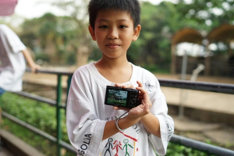 Cậu bé Võ Xuân Phát khoe bức ảnh em đã chụp được