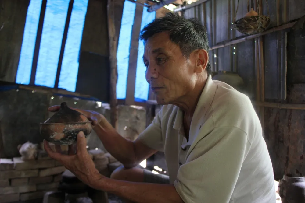 Ông Diễn giới thiệu về các sản phẩm của làng gốm Phước Tích. Ảnh: Nguyễn Do