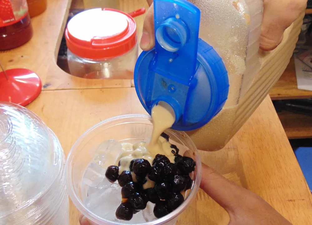 Một chủ quán đang pha chế trà sữa trân châu. Ảnh: TRẦN NGỌC