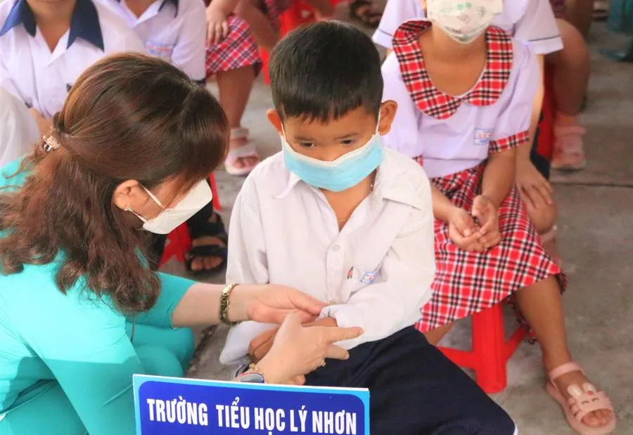 Cô giáo xắn tay áo cho một em học sinh. Ảnh: THẢO PHƯƠNG Cô giáo xắn tay áo cho một em học sinh. Ảnh: THẢO PHƯƠNG