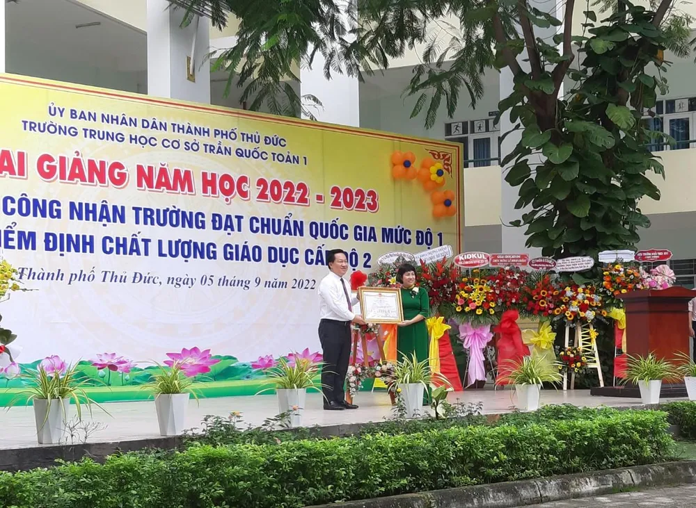Bà Nguyễn Thị Thu Hằng, Hiệu trưởng Trường THCS Trần Quốc Toản 1 (bìa phải) nhận Bằng công nhận trường đạt chuẩn Quốc gia cấp độ 1. Ảnh: TH