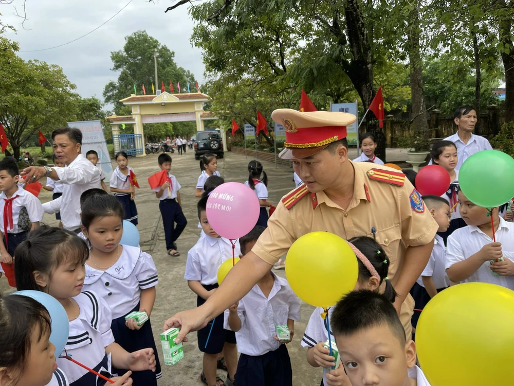 Chiến sĩ Trạm CSGT Phú Lộc, Phòng CSGT tỉnh Thừa Thiên Huế tặng sữa cho các em học sinh trong ngày khai giảng. Ảnh: Nguyễn Do