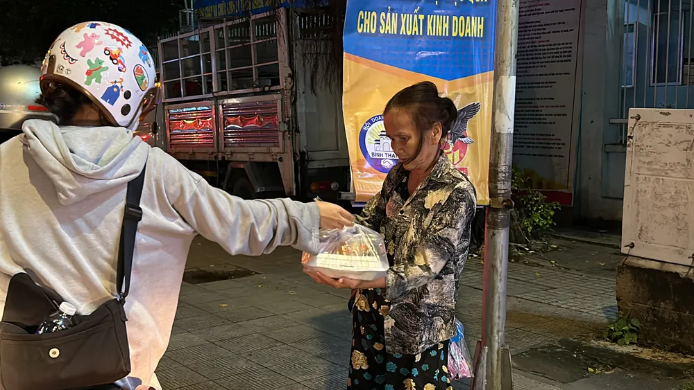 Họ hạnh phúc khi nhận được bữa ăn từ các bạn sinh viên. Ảnh: DLK13_CLC trao yeu thuong 5.jpg