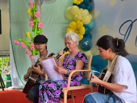 Cụ bà Đặng Thị Bê biểu diễn các ca khúc của cố nhạc sĩ Trịnh Công Sơn cùng ban nhạc “Gần Đây”. Ảnh: LONG VŨ vung nang bac 1.png