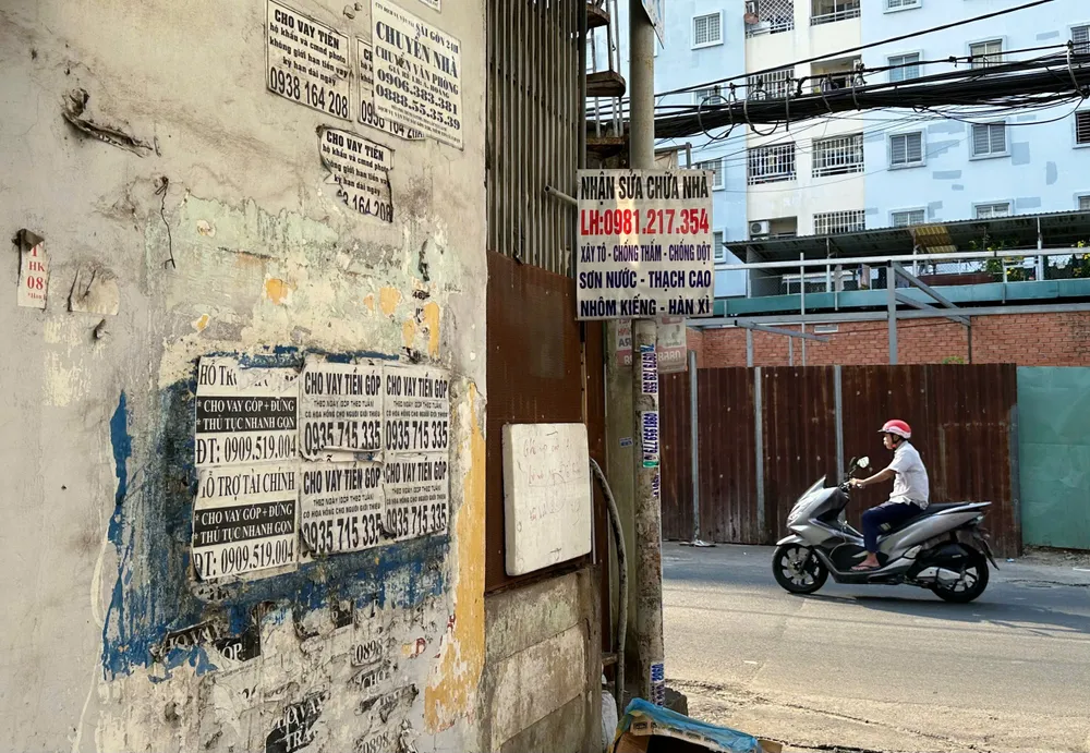 Quảng cáo vay tín dụng đen phủ khắp một con hẻm trên đường Nguyễn Thượng Hiền, phường 1, quận Gò Vấp. Ảnh: THẢO HIỀN TP.HCM quyết trị nạn vẽ bậy, quảng cáo tín dụng đen