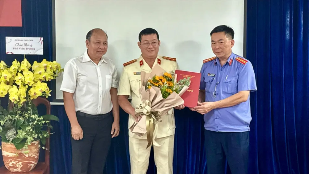 Phó Viện trưởng VKSND TP.HCM Ngô Phạm Việt trao quyết định cho ông Nguyễn Văn Khoăng. Ảnh: HUY TRUNG phó viện trưởng