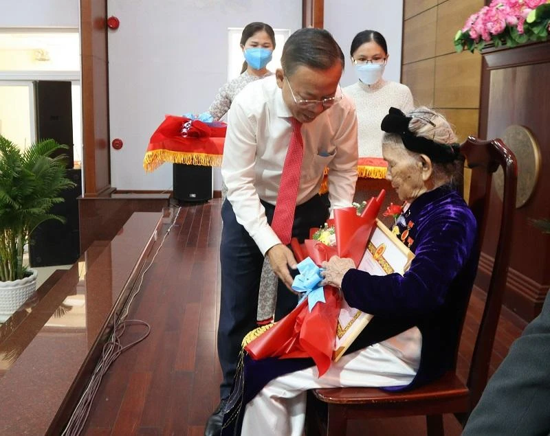 Bí thư Thành ủy TP Thủ Đức Nguyễn Hữu Hiệp trao huy hiệu 75 năm tuổi Đảng cho bà Phạm Thị Trọng. Ảnh: LƯƠNG HỢP