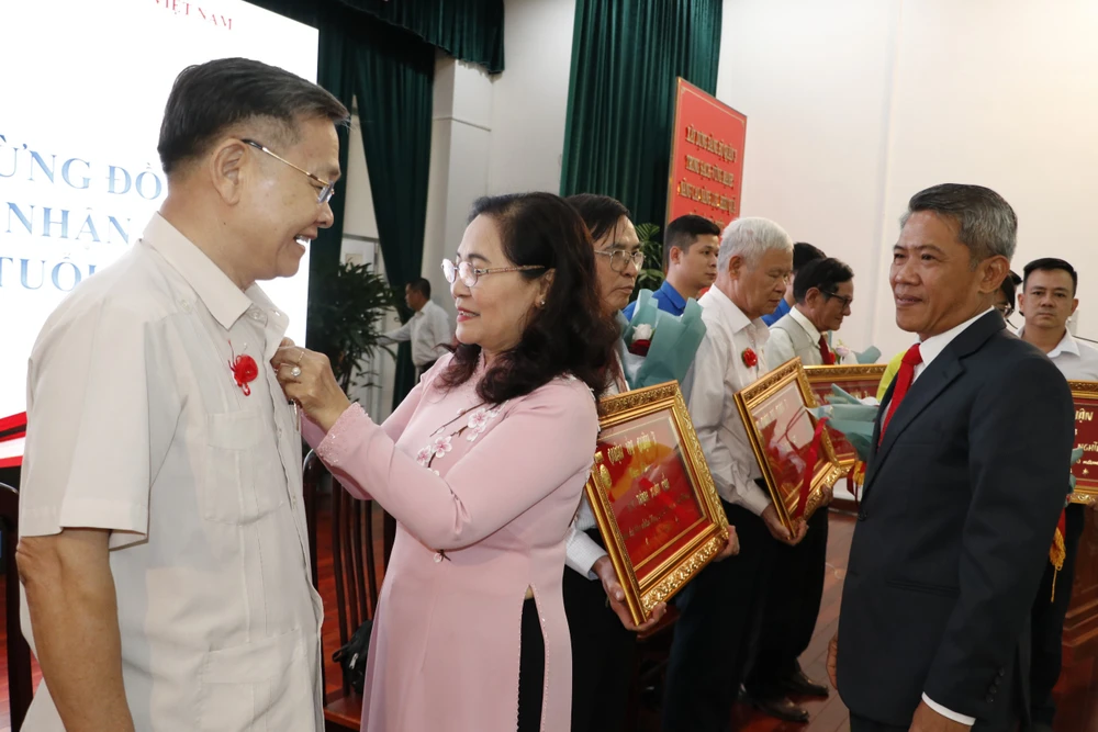 Phó Bí thư Thành ủy, Chủ tịch HĐND TP.HCM Nguyễn Thị Lệ trao huy hiệu đảng tại quận 3. ẢNH: THANH THÙY