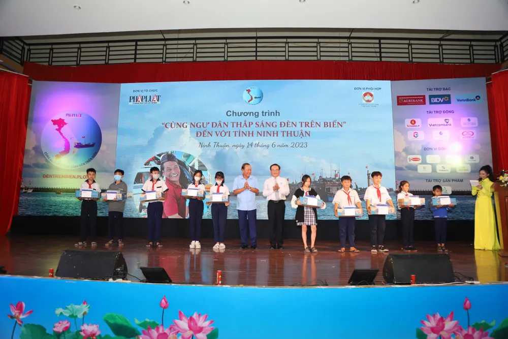 Ông Trương Hòa Bình, nguyên Phó Thủ tướng thường trực và ông Mai Ngọc Phước, Tổng biên tập báo Pháp Luật TP.HCM, trao tặng các suất học bổng cho các em học sinh.