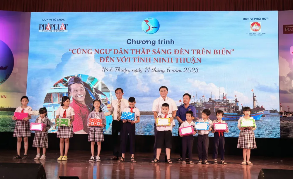 Ông Nguyễn Đức Hiển, Phó Tổng biên tập thường trực báo Pháp Luật TP.HCM và ông Nguyễn Hoàng Thành, Giám đốc kinh doanh Công ty Pinaco, trao học bổng cho các em học sinh.