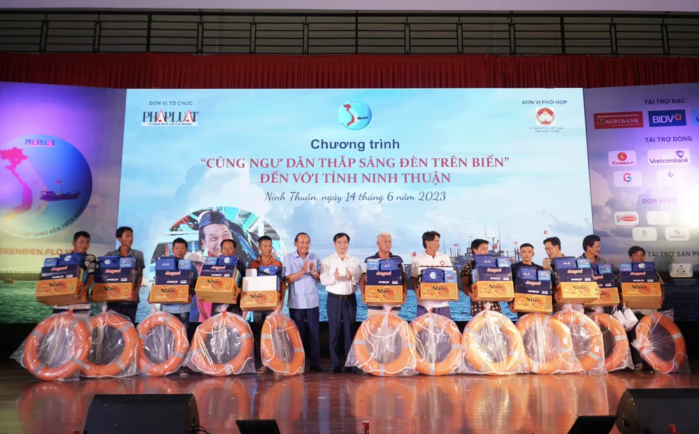 Ông Trương Hòa Bình, nguyên Phó Thủ tướng thường trực và ông Phan Xuân Thủy, Phó Trưởng ban Tuyên giáo Trung ương, trao tặng các phần quà cho các ngư dân Ninh Thuận.