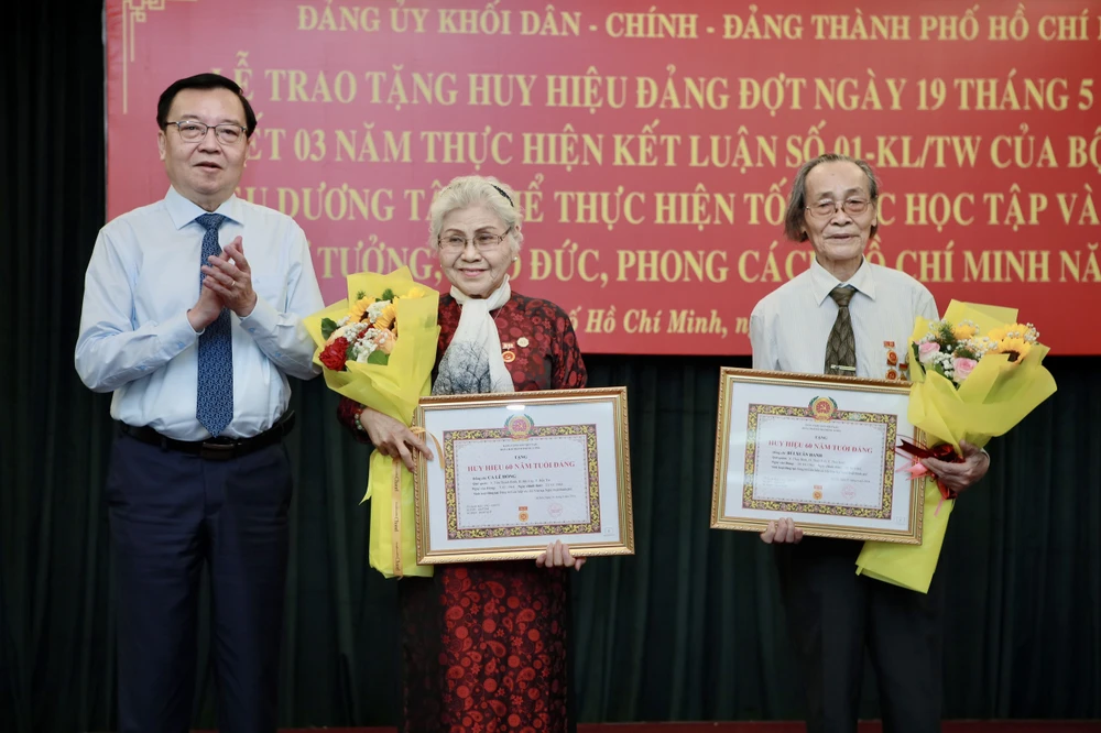 Ông Lê Hồng Sơn - Phó Trưởng ban thường trực Ban Tuyên giáo Thành ủy TP.HCM trao huy hiệu 60 năm tuổi Đảng cho hai đảng viên. Ảnh: NGUYỆT NHI dang-uy-khoi-trao-huy-hieu-dang-19-5 (2).jpg
