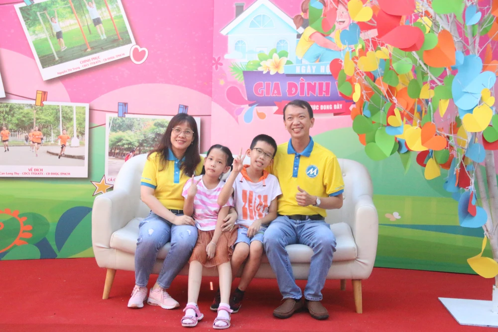 Vợ chồng anh Nguyễn Hoàng Vinh cùng hai con tham gia chụp ảnh gia đình. Ảnh: THẢO PHƯƠNG