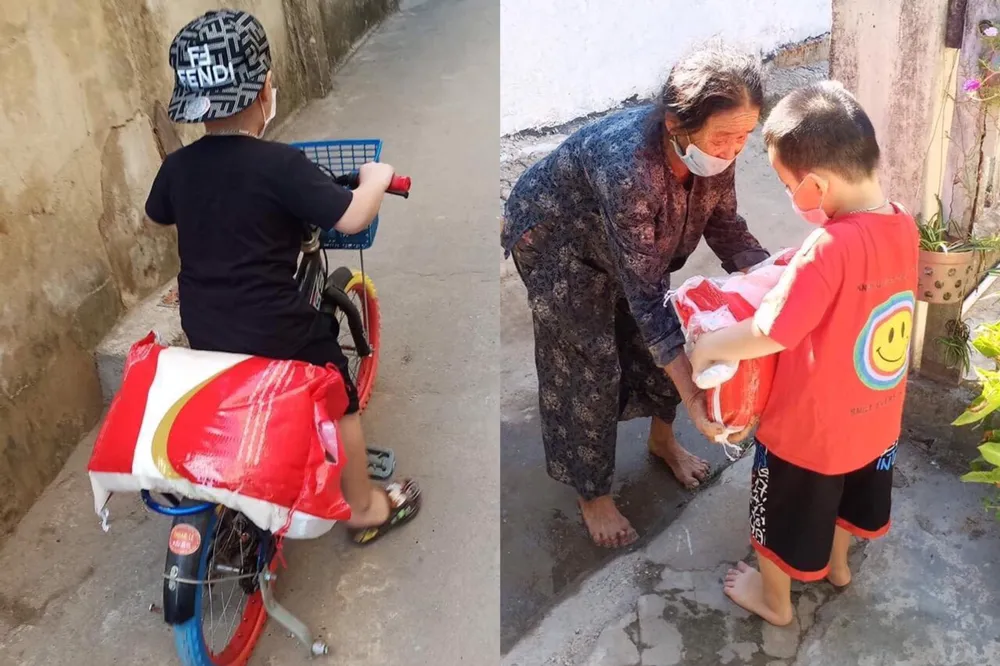 Nhật Khang (lúc 5 tuổi) trao tận tay những bao gạo cho các cụ già. Ảnh: NVCC