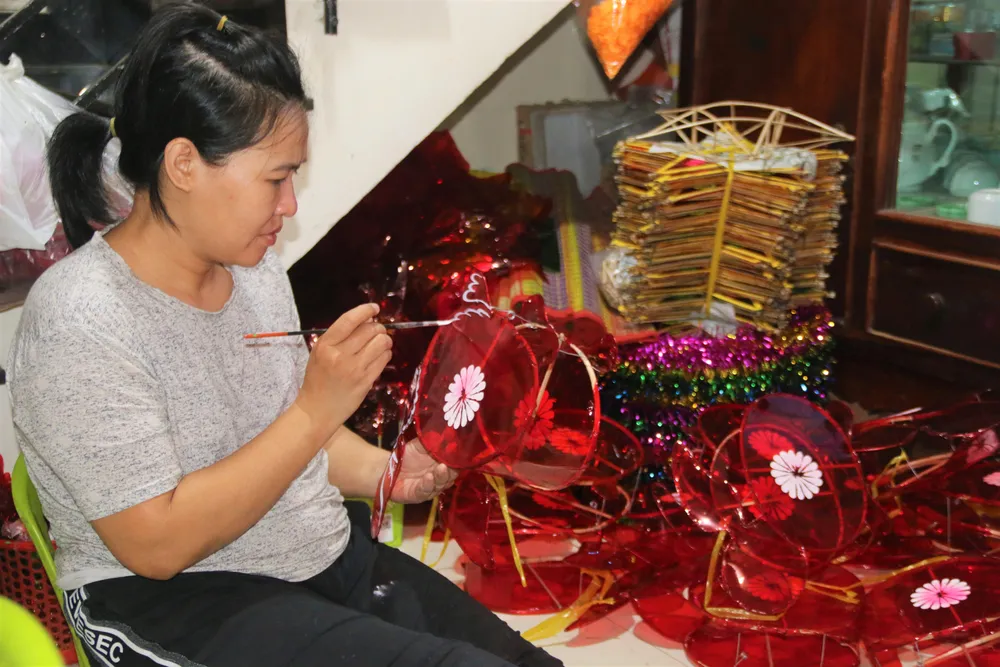 Em chồng chị Thu tỉ mi vẽ trang trí cho lồng đèn. Ảnh: THẢO PHƯƠNG Em chồng chị Thu tỉ mi vẽ trang trí cho lồng đèn. Ảnh: THẢO PHƯƠNG