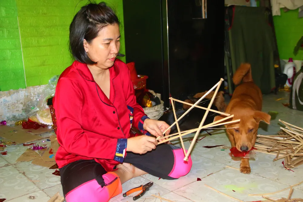 Chị Nguyễn Kim Thu chăm chú làm trung cho chiếc đèn ông sao. Ảnh: THẢO PHƯƠNG Chị Nguyễn Kim Thu chăm chú làm trung cho chiếc đèn ông sao. Ảnh: THẢO PHƯƠNG