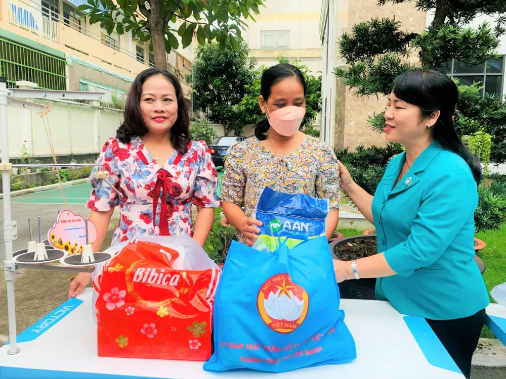 Bà Trần Kim Yến ân cần thăm hỏi gia đình hộ nghèo được tặng quà. Ảnh: TÚ NGÂN