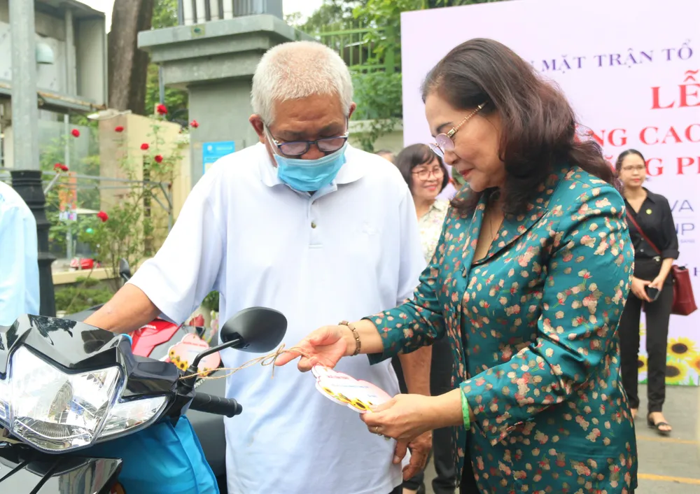 Bà Nguyễn Thị Lệ - Phó Bí thư Thành ủy, Chủ tịch Hội đồng nhân dân TP.HCM chia sẻ niềm vui cùng người dân được nhận xe máy. Ảnh: TÚ NGÂN