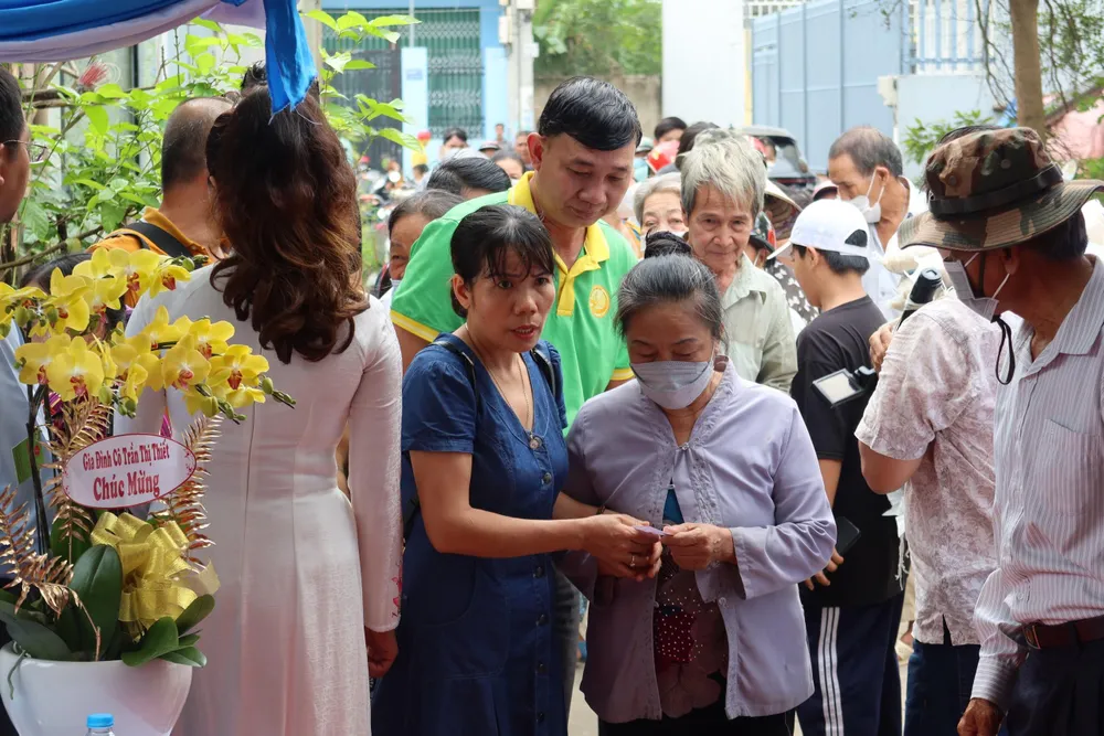 Người dân lấy phiếu nhận quà từ thiện. Ảnh: TRẦN MINH Người dân lấy phiếu nhận quà từ thiện. Ảnh: TRẦN MINH