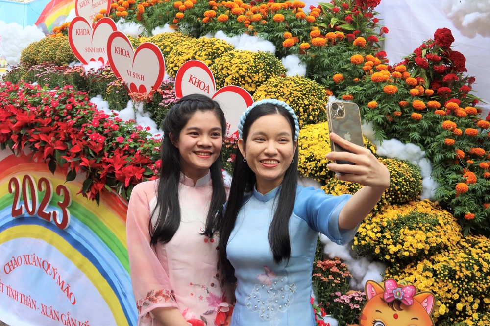 Chị Lê Thị Yến Khoa (áo hồng) cùng chị Nguyễn Hồng Phương Quỳnh (áo xanh) lưu lại khoảnh khắc xuân rộn ràng. Ảnh: TRẦN MINH