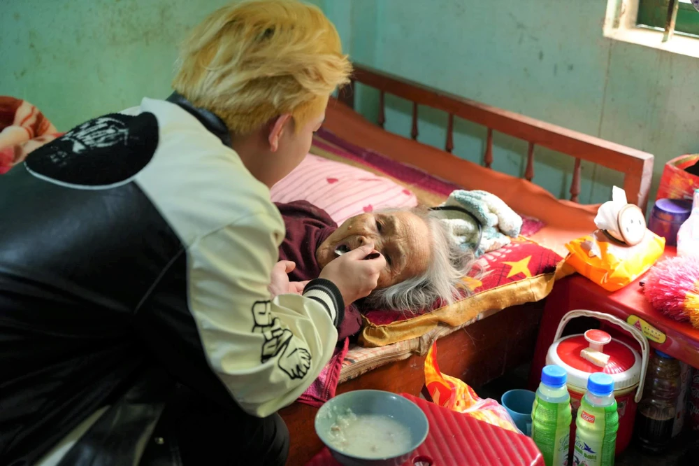 Nguyễn Hữu Long đút cháo cho bà Huỳnh Thị Phố. Ảnh: BTC