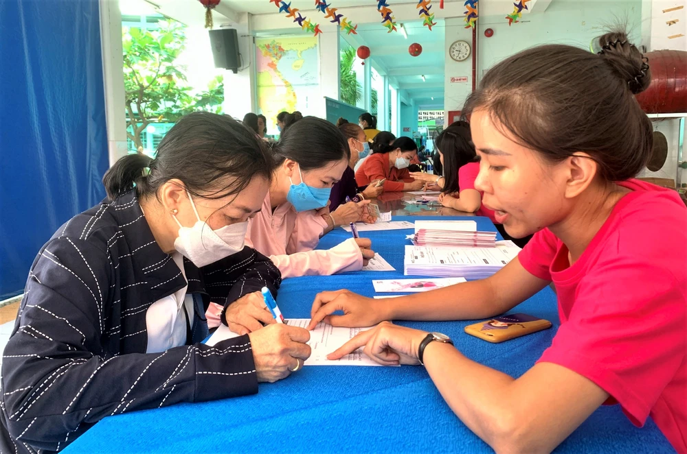 Người dân điền thông tin vào phiếu khám. Ảnh: THẢO PHƯƠNG