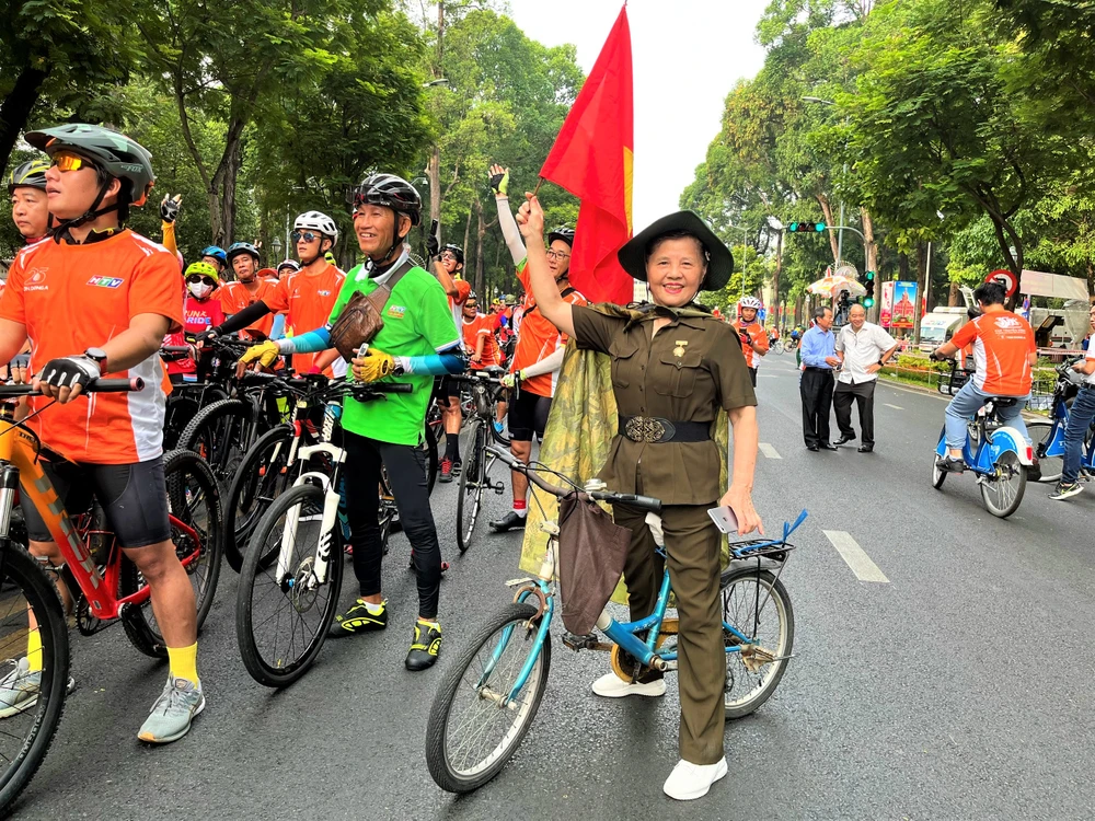 Bà Nguyễn Thị Thảo (76 tuổi) mượn xe đạp của cháu để đạp xe diễu hành đón đoàn đua xe đạp chào mừng ngày đại thắng. Bà cho biết, vào 48 năm trước, đúng ngày 30-4, bà cùng cơ quan ra đường đón chào Ngày Giải phóng miền nam - Thống nhất đất nước. Ảnh: THẢO PHƯƠNG