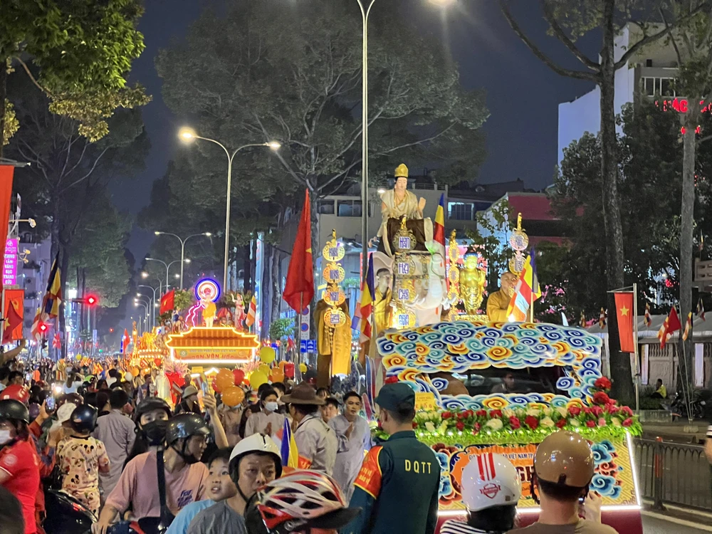Người dân di chuyển trên tuyến đường Ba tháng hai dừng xe, cùng tham gia vào đoàn rước kiệu. Ảnh: QUỐC HƯƠNG