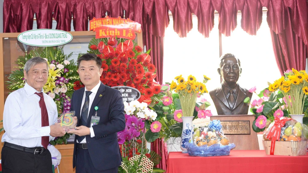 PGS-TS-BS Nguyễn Thanh Hiệp, Hiệu trưởng nhà trường tặng kỉ niệm chương cho ông Dương Anh Tuấn, con trai cố viện sĩ Dương Quang Trung. Ảnh: THẢO PHƯƠNG