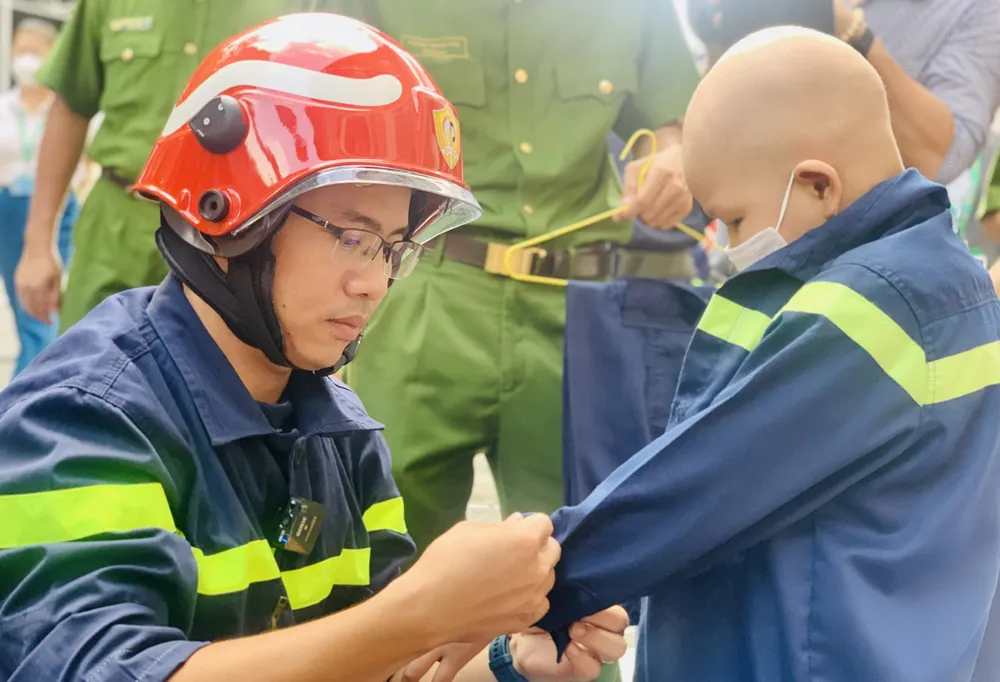 Đại úy Đỗ Ngọc Đức khoác cho Quân bộ đồ của người lính cứu hỏa. Ảnh: THẢO PHƯƠNG